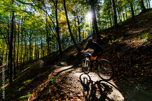 Cycling woman riding on bike in summer mountains forest landscape. Woman cycling MTB flow trail track. Outdoor sport activity. © Gorilla