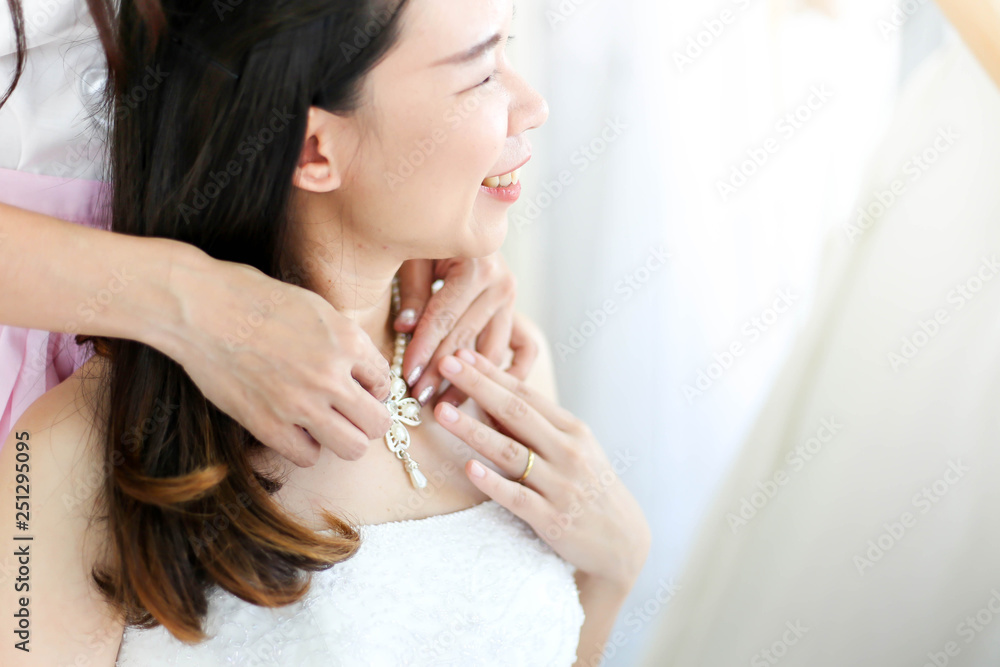 Beautiful bride getting dressed by her best friend in her wedding day and choosing a wedding dress in the shop and the shop assistant is helping her Beautiful bride getting dressed by her best friend in her wedding day and choosing a wedding dress in the shop and the shop assistant is helping her