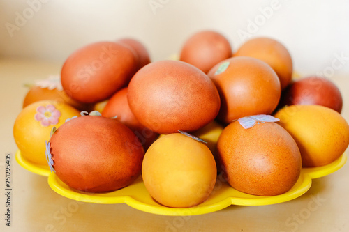 Orange Easter eggs on the yellow plate