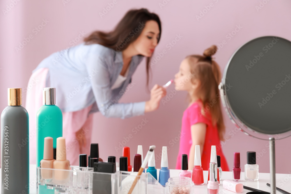 Cute daughter with mother doing makeup at home Cute daughter with mother doing makeup at home