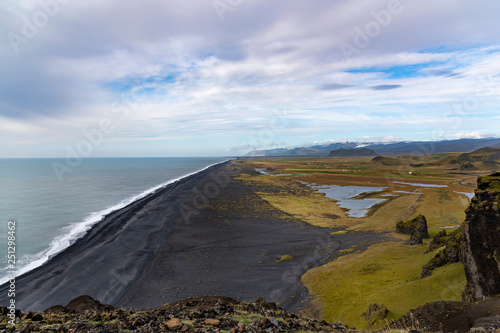 Top view landscape taken on the mountain in Iceland with beautiful view of black sand beach, rock mountain and clouded sky 