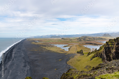 Top view landscape taken on the mountain in Iceland with beautiful view of black sand beach, rock mountain and clouded sky