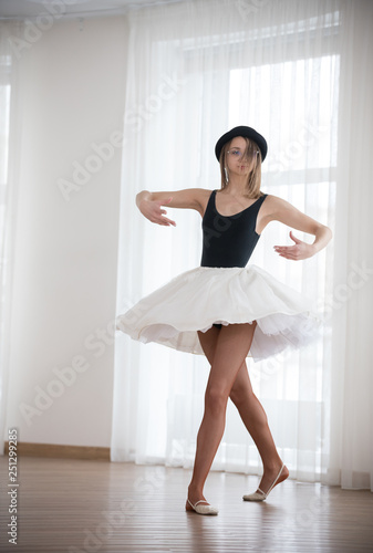 Ballerina in the hat is dancing in the studio