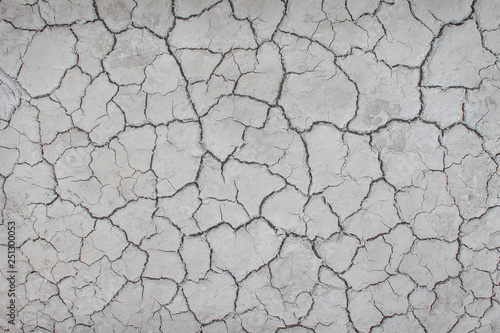 Top view cracked patterns of soil ground texture for grey white background , nature drought