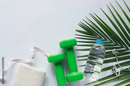 Top view healthy object on white background with dumbbells, water and headphones for sport or exercise concept.