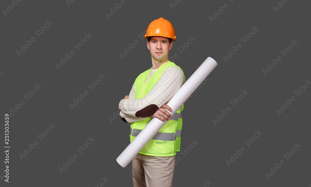 the man the builder in a helmet holds drawings, documents in hand, looks in the camera the man the builder in a helmet holds drawings, documents in hand, looks in the camera