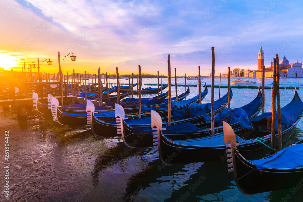 Gondolas moored by Saint Mark square with San Giorgio di Maggiore church in Venice, Italy