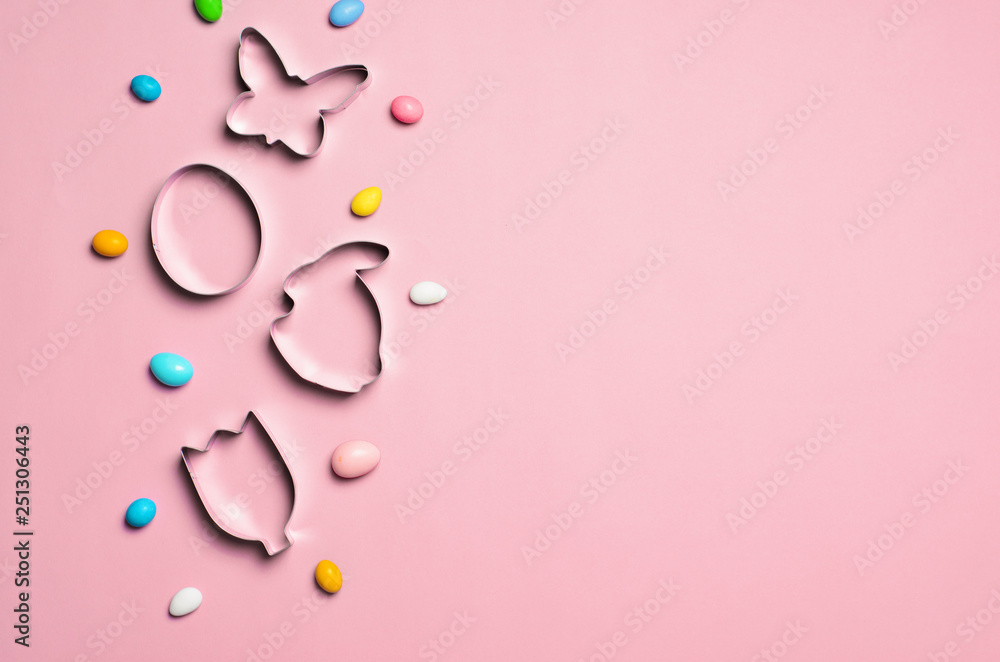 Easter Concept, Cookie Cutters and Chocolate Eggs on Pink Background