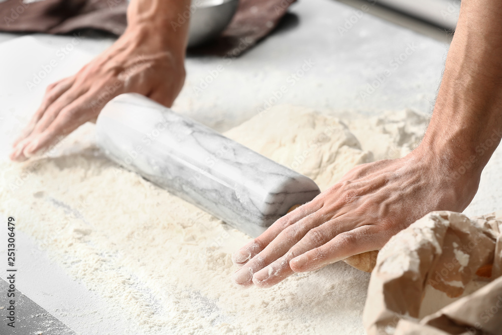 Young man preparing dough for bread in kitchen, closeup Young man preparing dough for bread in kitchen, closeup