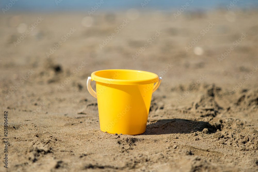 yellow plastic bucket on beach yellow plastic bucket on beach