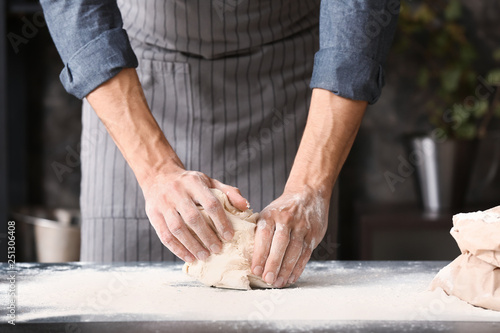 Young man preparing dough for bread in kitchen © Pixel-Shot