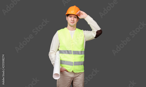 the man keeps a paper roll, a hand under a peak in a helmet