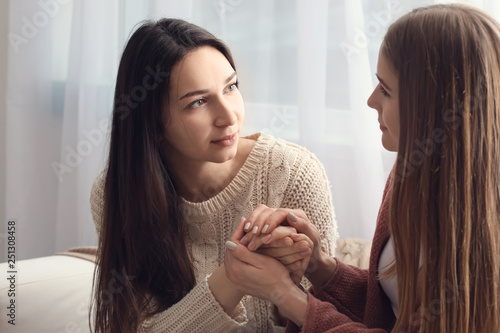 Friend helping young depressed woman at home. Stop a suicide