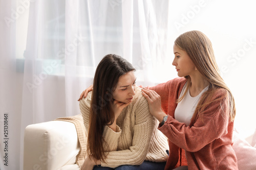 Friend helping young depressed woman at home. Stop a suicide