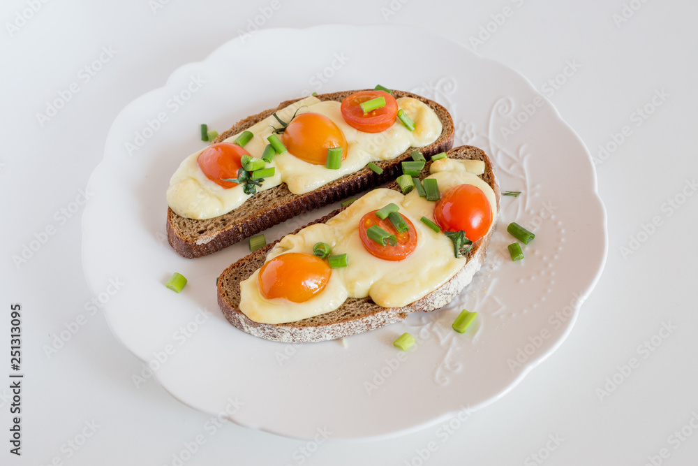 Multigrain toast bread with melt gouda or kaseri cheese and small tomatoes and green onion on top 