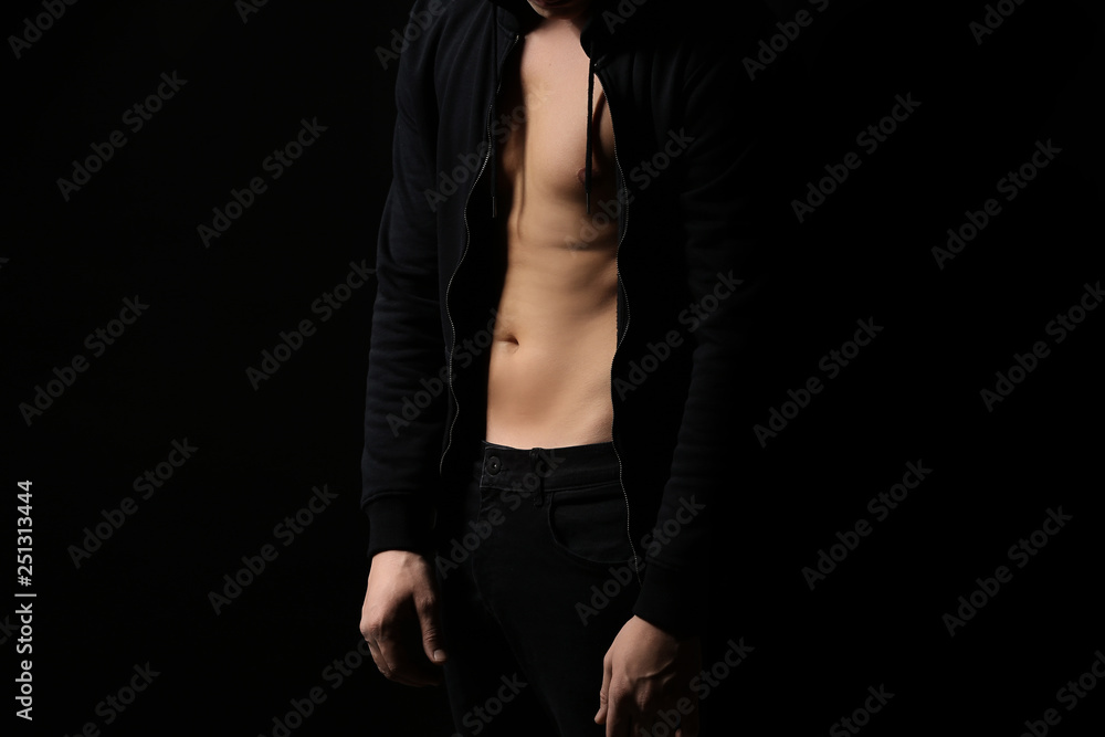 Sporty young man against dark background Sporty young man against dark background