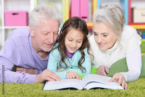 Portrait of little cute girl with grandparents studying