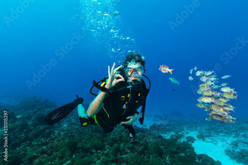 Young woman scuba diver showing OK gesture. photo