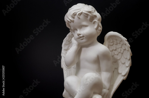 Beautiful white angel on black background close-up. Symbol of love, faith and hope © yaroslav1986