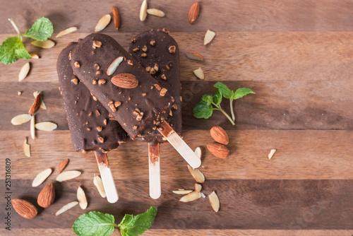 Ice cream covered with chocolate and almonds sticks. Top view. photo