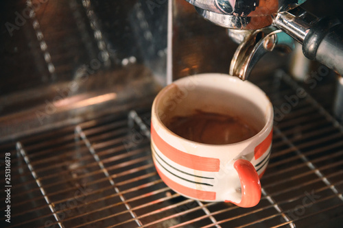 Coffee maker machine grinder pouring coffee in mug
