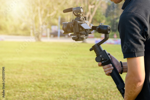 Professional videographer with camera on gimbal stabilizer for taking photo