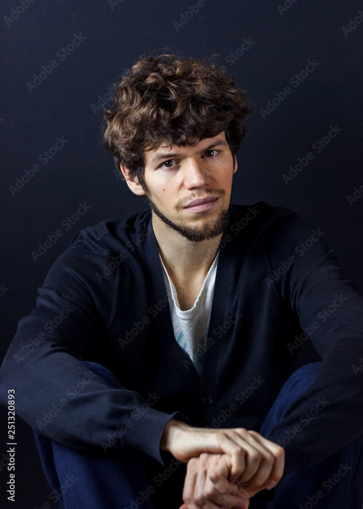 Curly man portrait on dark studio background