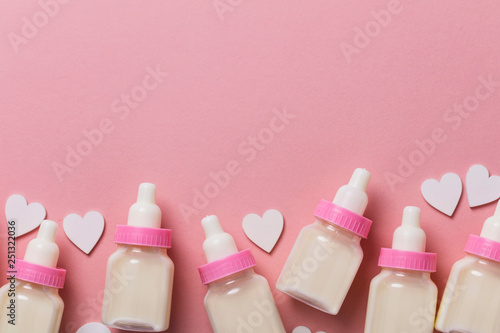 Baby bottle on a pastel pink background. New baby arrival photo