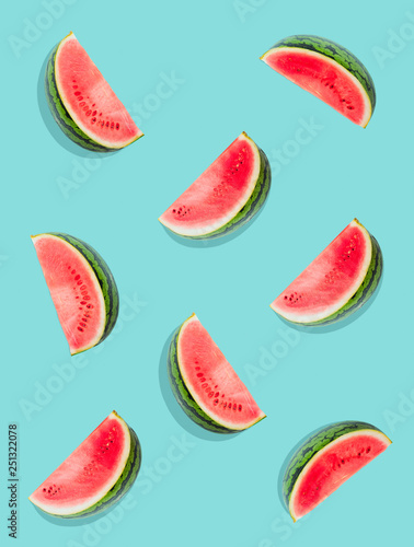 Fototapeta Naklejka Na Ścianę i Meble -  Watermelon pattern. Slices of watermelon on a plain surface painted in bright blue