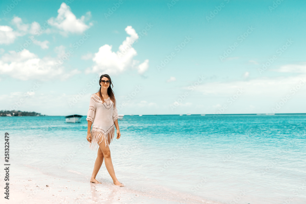 Full length of gorgeous Caucasian woman in summer dress posing on a beach. Summer holidays concept. Full length of gorgeous Caucasian woman in summer dress posing on a beach. Summer holidays concept.