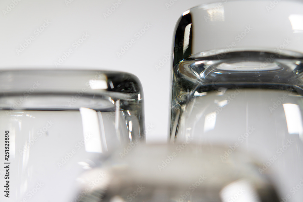 Close up of three different empty shot glasses on white background. Close up of three different empty shot glasses on white background.