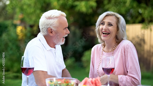 Senior couple laughing at dining table  telling funny jokes  remembering moments