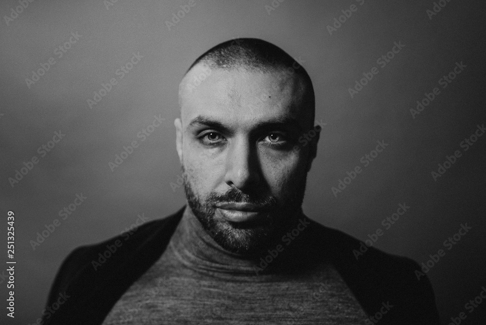 Studio fashion portrait in monochrome. Elegant young handsome serious man.