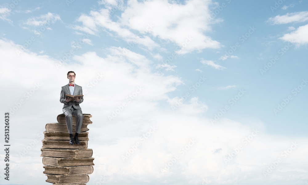 Young businessman or student floating in blue sky and studying the science Young businessman or student floating in blue sky and studying the science