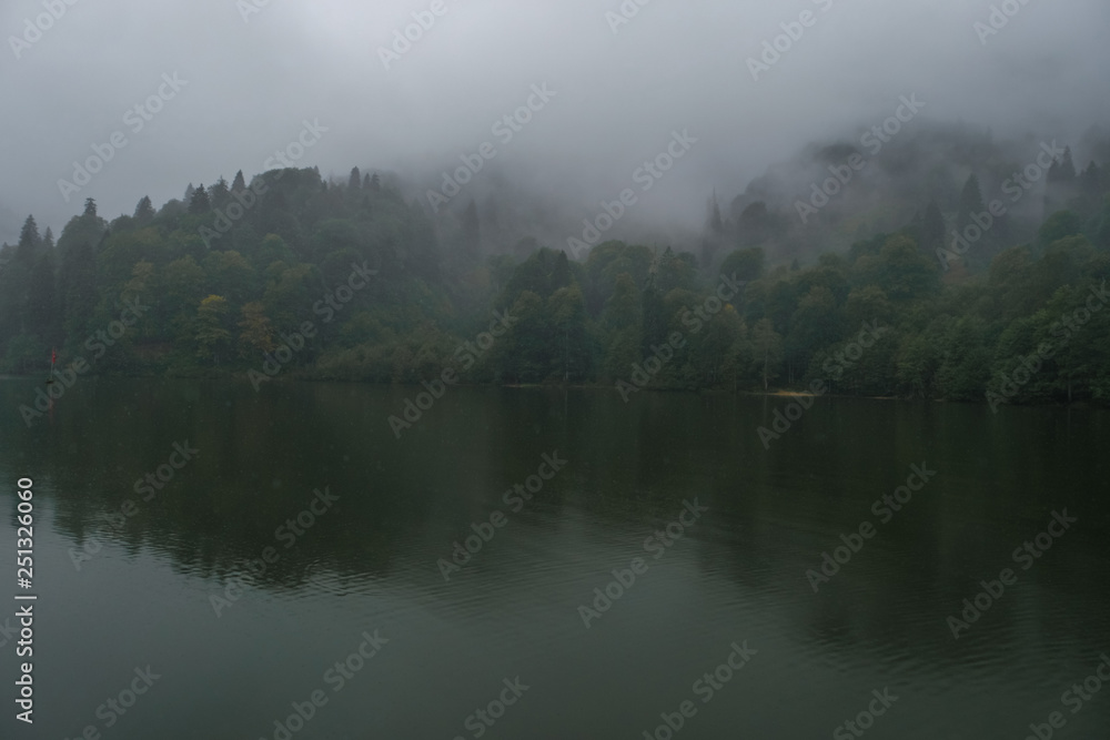 Misty hills over lake.