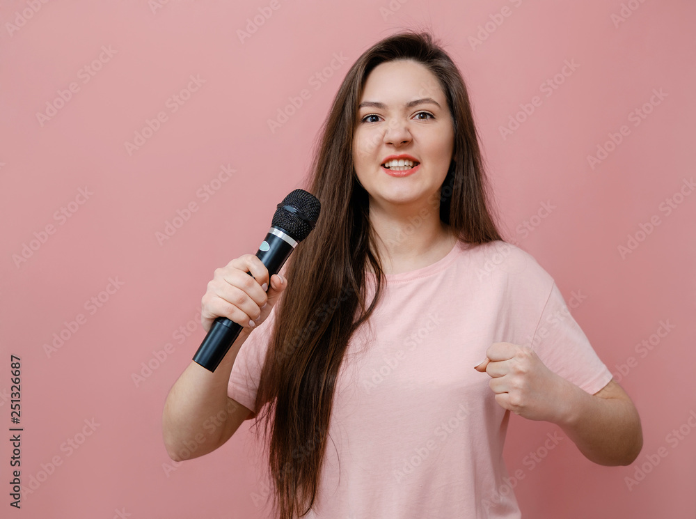 young protest woman with microphone in hand on pink background young protest woman with microphone in hand on pink background