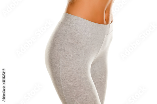 sexy slim female hips in gray leggingss on white background