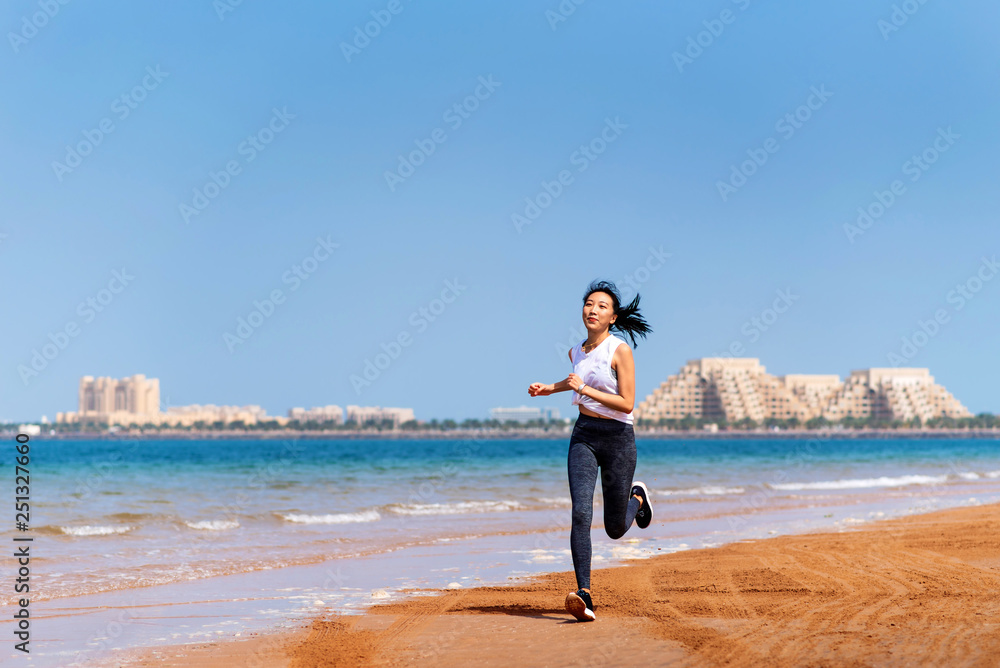 Woman running on the beach on a sunny day Woman running on the beach on a sunny day