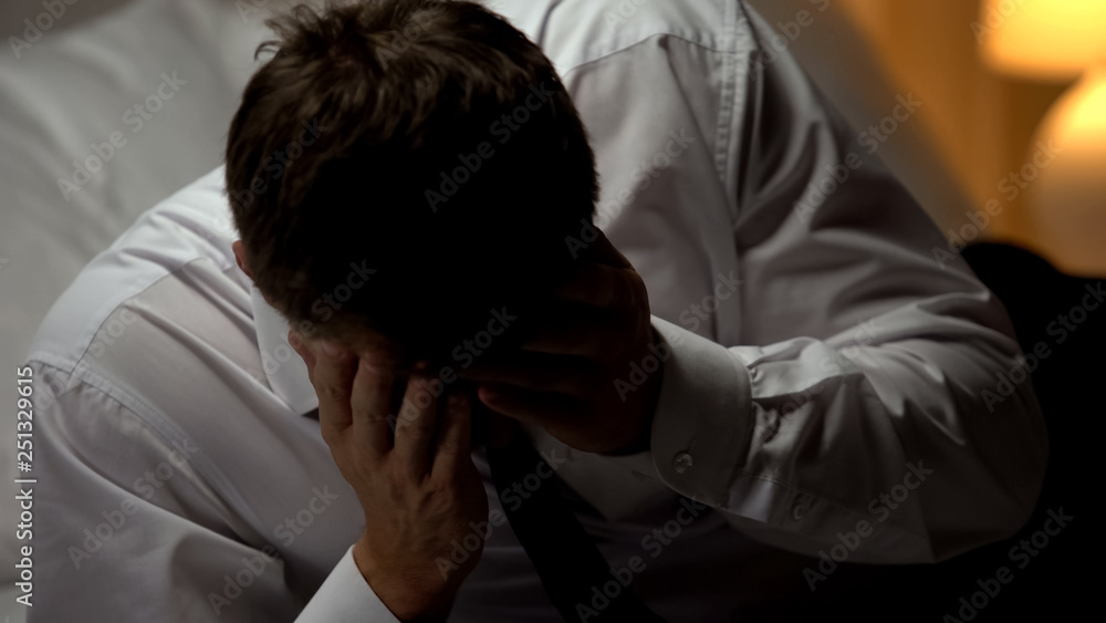 Businessman suffering headache, migraine problem caused by stressful lifestyle Businessman suffering headache, migraine problem caused by stressful lifestyle