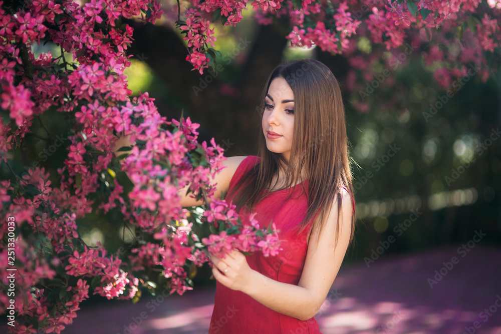 Beautiful lady stand by the big blooming tree voilet color. Happy girl with makeup in spring Beautiful lady stand by the big blooming tree voilet color. Happy girl with makeup in spring