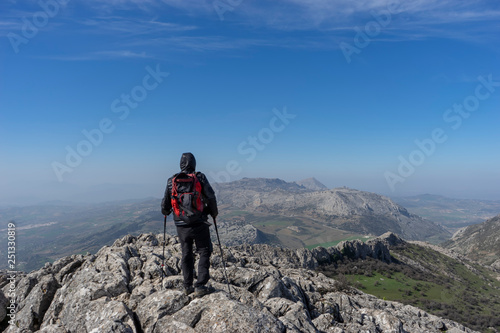 senderista en la cima de la montaña y frente al torcal de Antequera