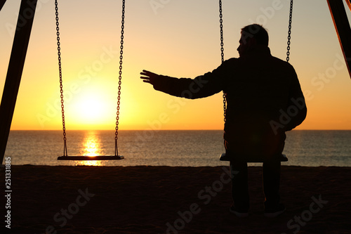 Man alone missing her partner at sunset