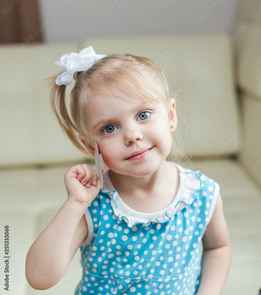 cute smiling baby 3 years old blonde-haired, blue-eyed shears out paper and  sticks on paper Stock Photo | Adobe Stock