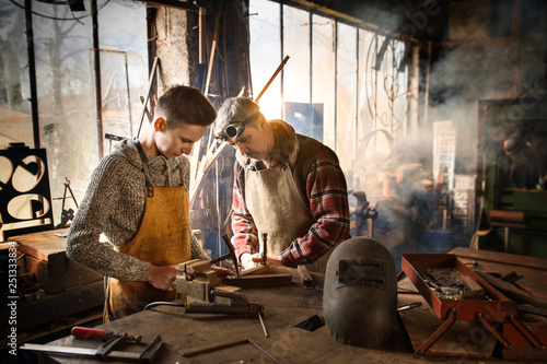 A craftsman in his workshop teaches his work to his apprentice