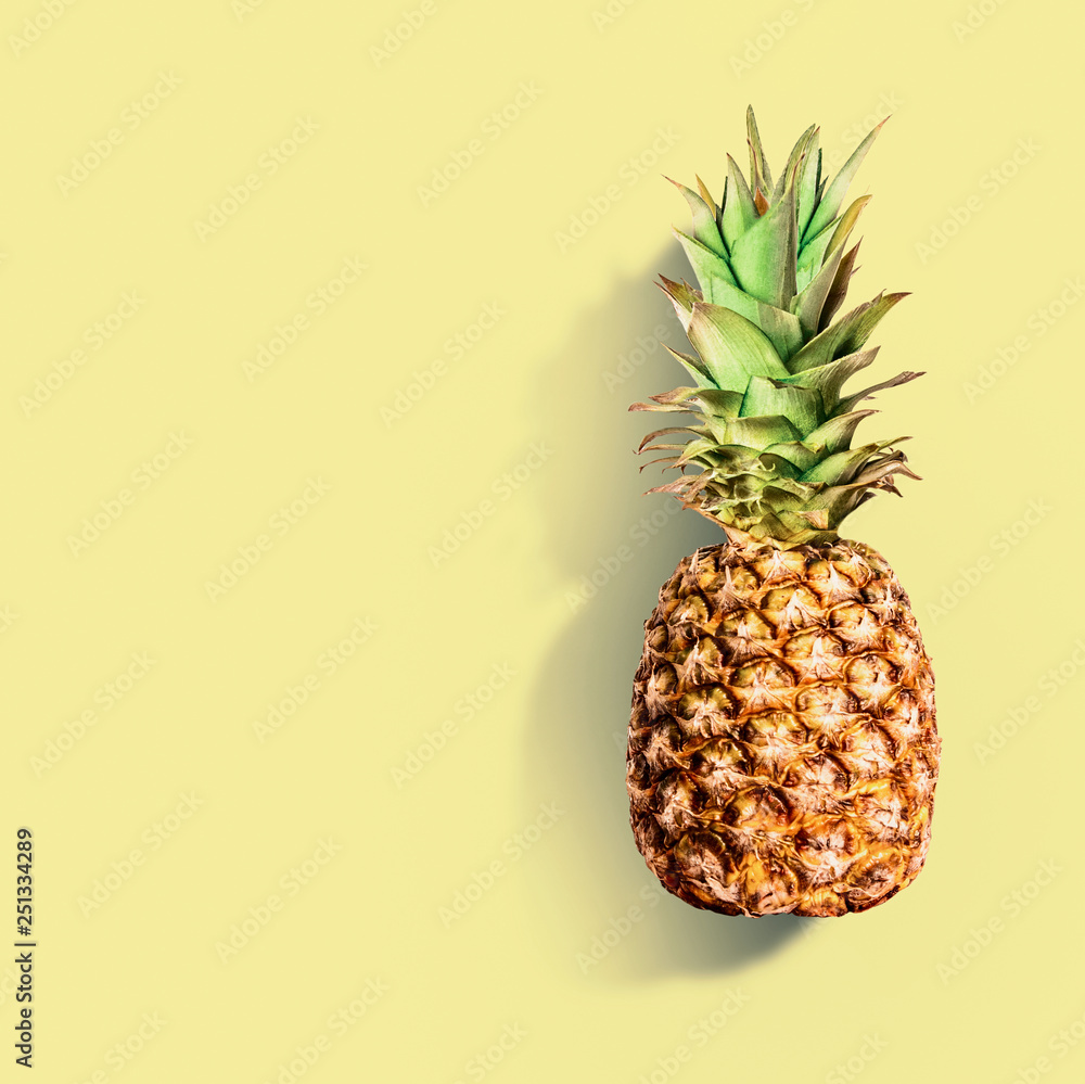 Pineapple at yellow background. Summer tropical fruits concept. Copy space for your design