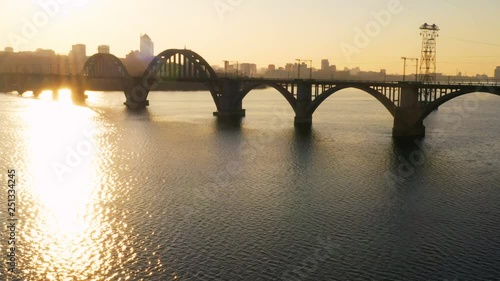 sunset aerial view of railroad bridge across the river and city skyline, Dnepr, Ukraine photo