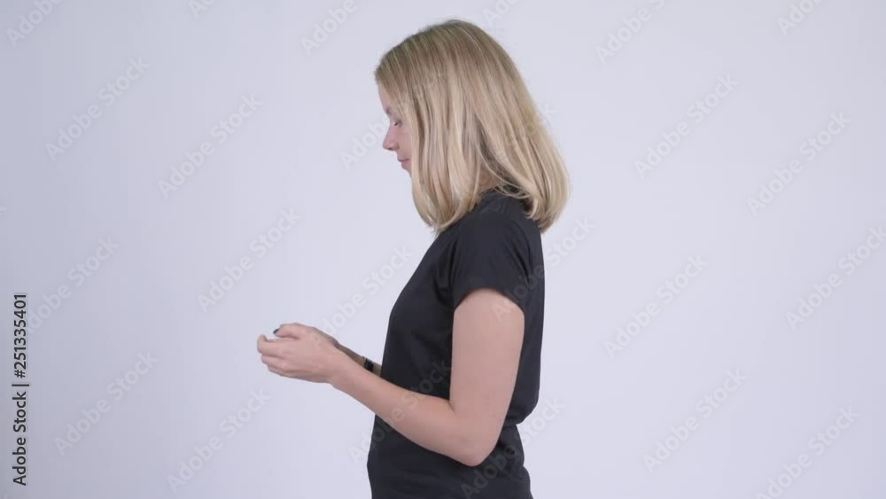 Profile view of young blonde woman with phone being taken away Profile view of young blonde woman with phone being taken away
