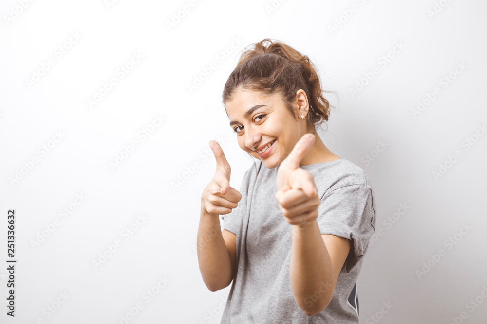 Smiling Indian girl points fingers at the camera. Smiling Indian girl points fingers at the camera.
