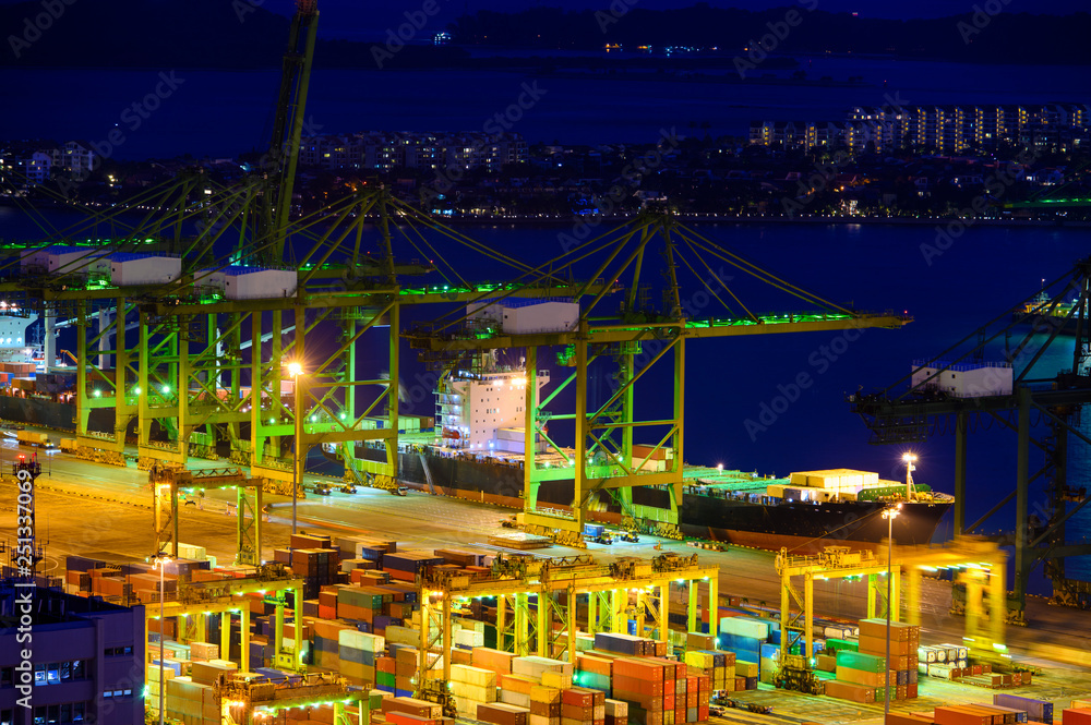 Harbor with lots of cranes and cargo containers during dusk
