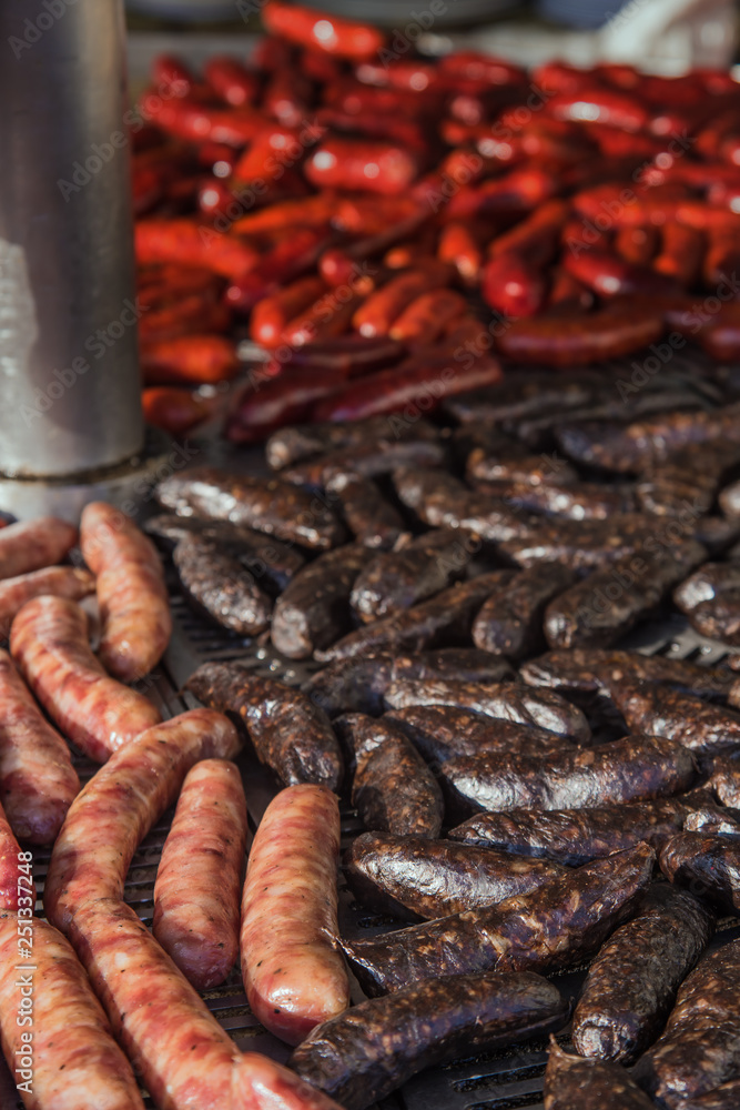 Fototapeta premium Different kinds of fresh spanish sausages hanging in bunches on the marketplace. Soft focus.8